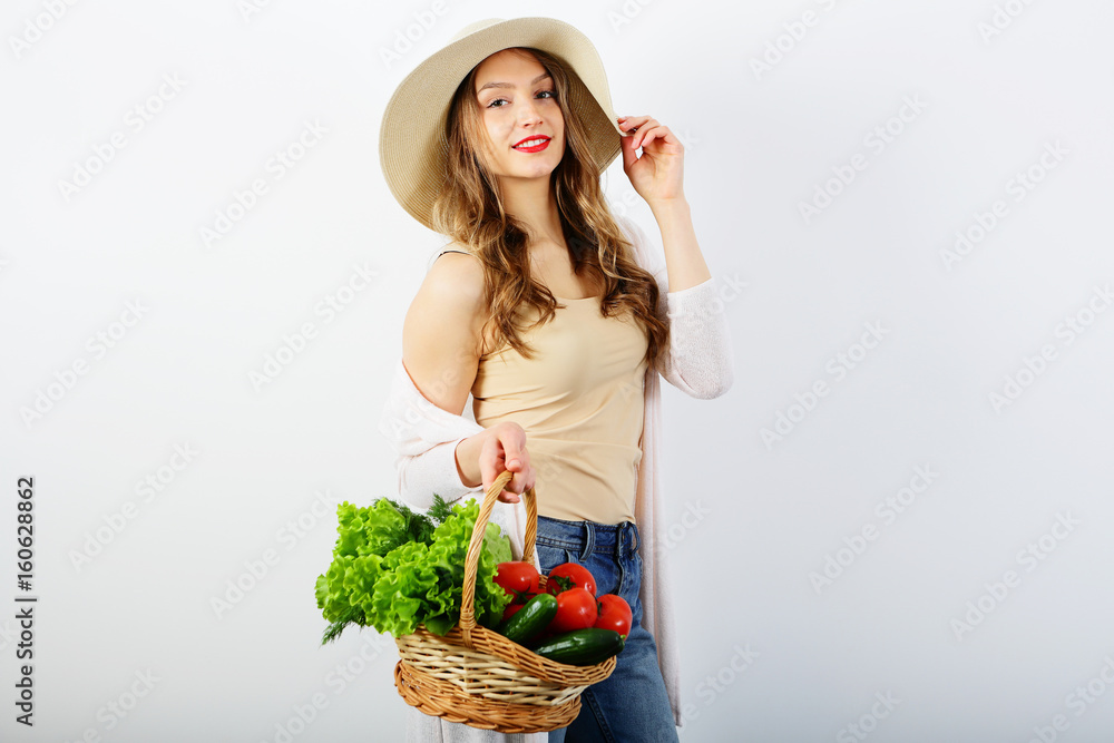 Beautiful girl holding wicker basket of healthy food, vegetables, on white background, copy space Beautiful girl holding wicker basket of healthy food, vegetables, on white background, copy space