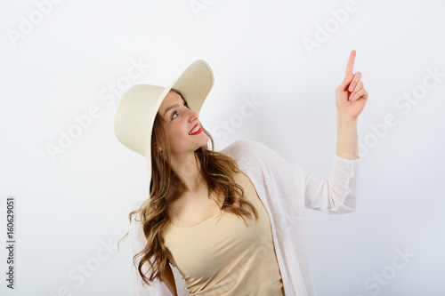 Woman points with finger , copy space, on white background photo