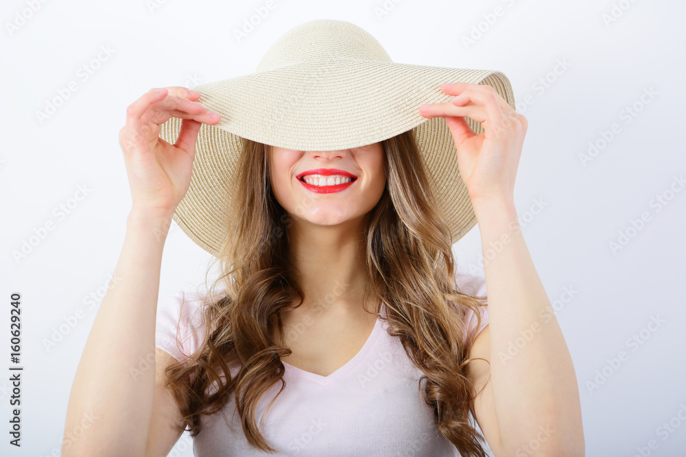 Smiling woman wavy hair red lips, covers face, on white background