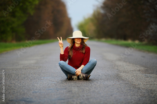 Funny girl sitting on road, traveler, freedom, young, natural background