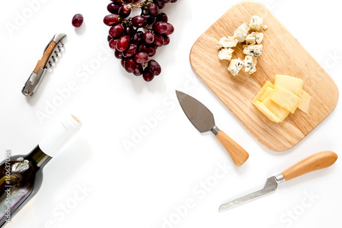 Slika na platnu Bottle of red wine with cheese and grape aperitive on white background space for