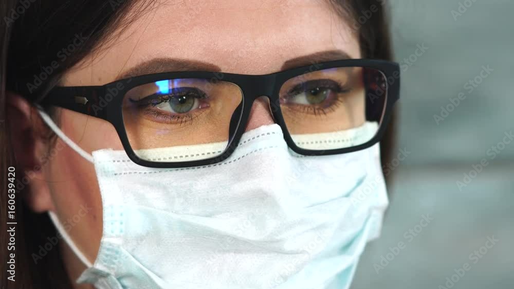Face of female scientist or doctor in white protective mask. Close up view. Concept of different professions. Face of female scientist or doctor in white protective mask. Close up view. Concept of different professions.