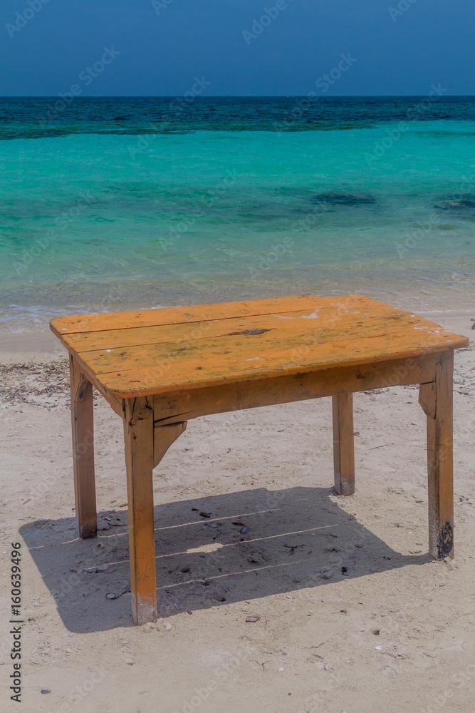 Table on the tropical beach. Mucura island of San Bernardo archipelago, Colombia Table on the tropical beach. Mucura island of San Bernardo archipelago, Colombia