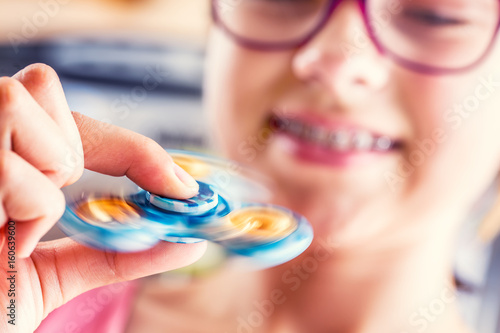 Fidget Spinner. Cute young girl playing with fidget spinner. photo