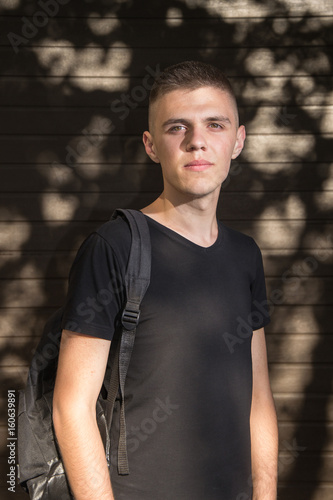 Teenage Boy looking at camera on background of Urban wall