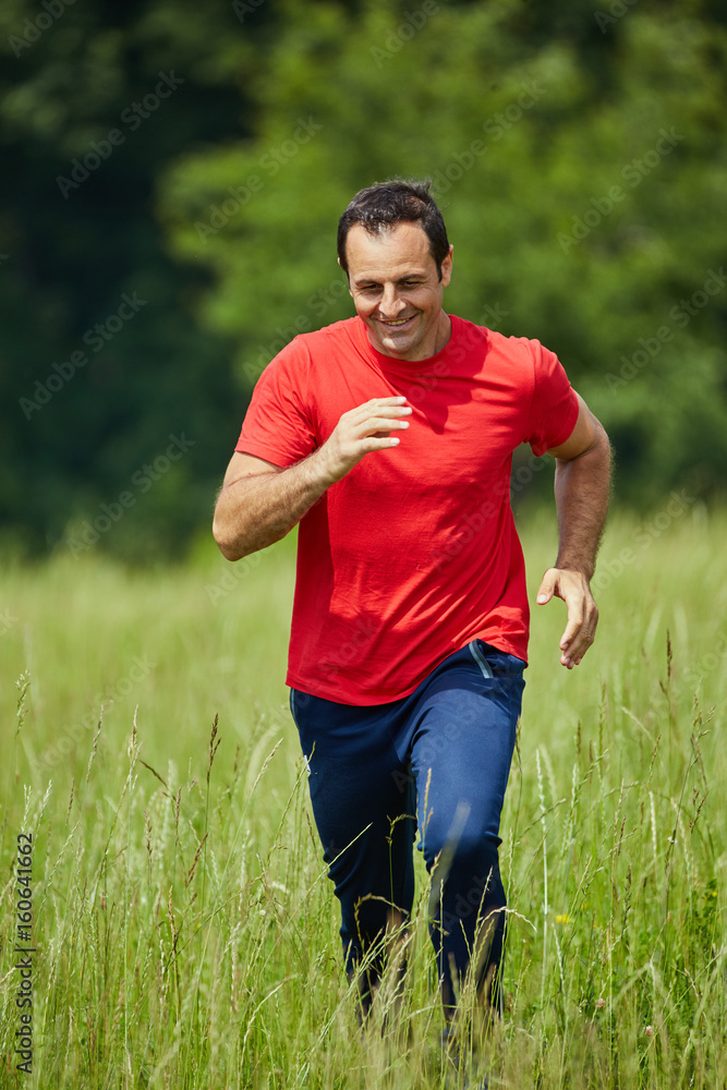 Fototapeta premium Man trail running by the forest