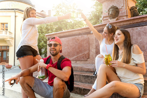 Fotografia Group of friends having fun n ext to the the public fountain on summer day