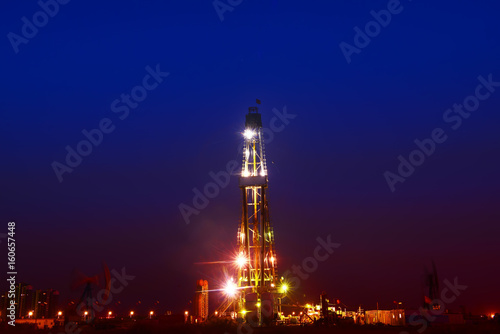 The oil derrick in work, in the oil field in the evening