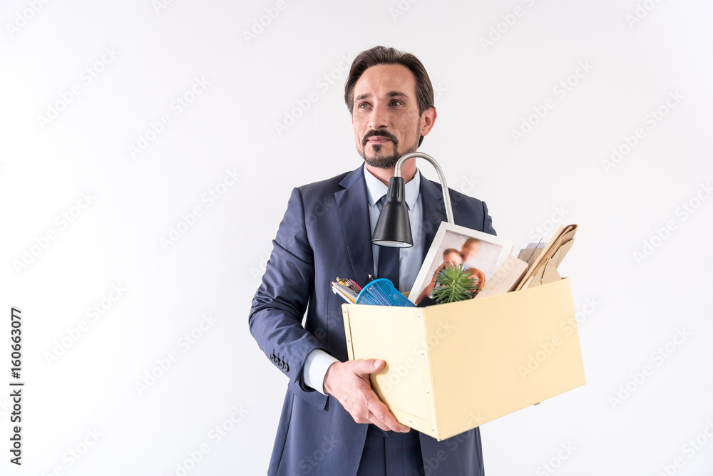 Attractive adult bearded man is holding box with his things Attractive adult bearded man is holding box with his things