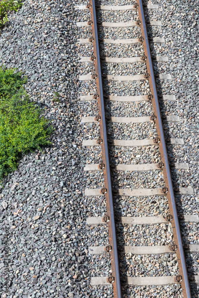 Above a railroad in a rock with grass.
