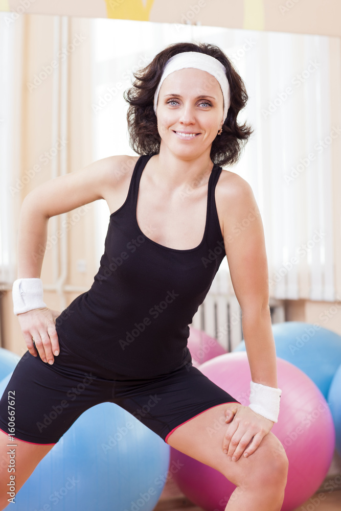 Sport, Fitness, Wellness and Lifestyle Ideas.Portrait of Female Caucasian Athlete In Good Fit Posing Against Fitballs in Gym.
