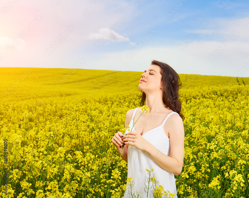 Woman in field with yellow flowers at summer sunset. Woman in field with yellow flowers at summer sunset.