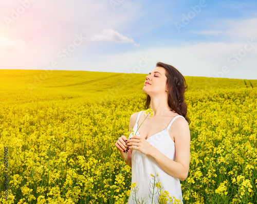 Woman in field with yellow flowers at summer sunset. © acnaleksy
