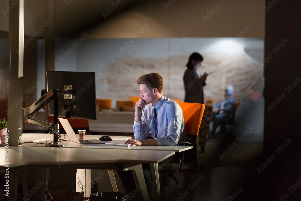 man working on computer in dark office man working on computer in dark office