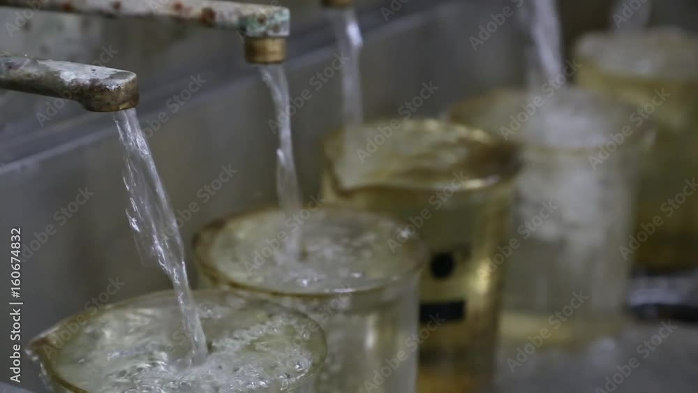 Several taps with water are filling several test tubes at once to overflow. Laboratory in a water treatment plant. Several taps with water are filling several test tubes at once to overflow. Laboratory in a water treatment plant.