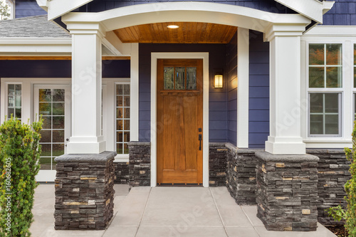 New Luxury Home Exterior Detail: New House Front Door and Covered Patio with Arch, Columns, and Elegant Design