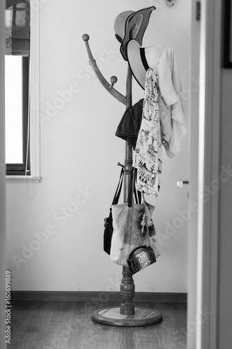 A coat rack with clothes and bags in the room