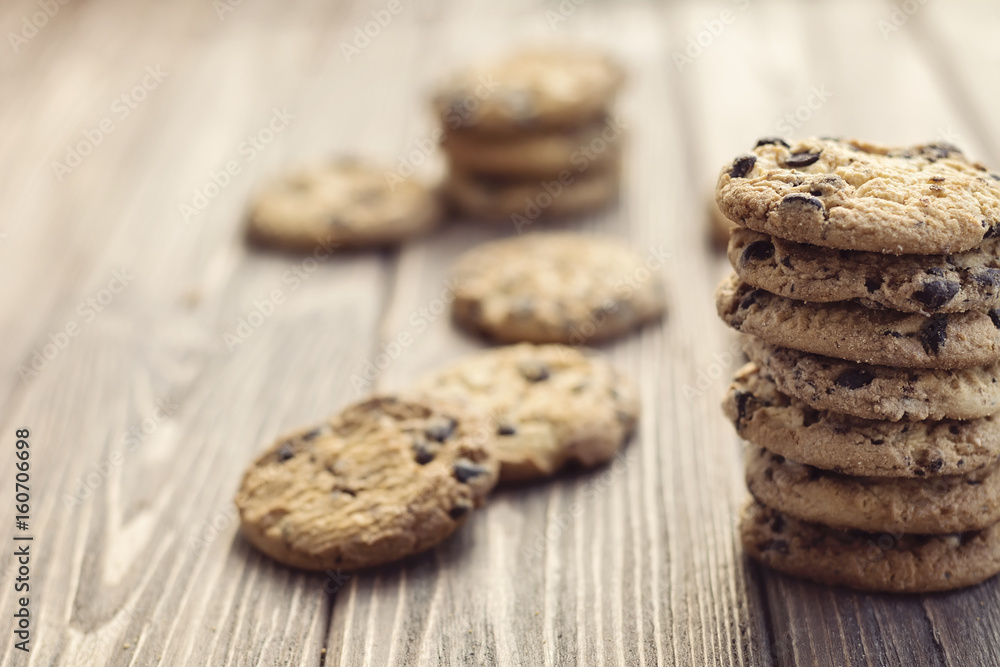 Stack of oat cookies with chocolate drops on brown wooden background Stack of oat cookies with chocolate drops on brown wooden background