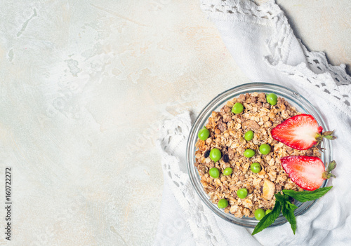 Sweet country breakfast: granola with strawberries and Green peas on vintage background. healthy eating concept. Top view, flat lay