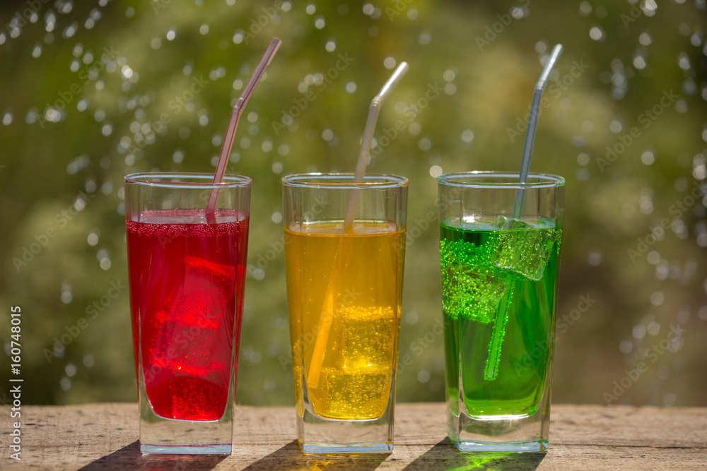 Three glasses of soda water on an old board, on the nature Three glasses of soda water on an old board, on the nature