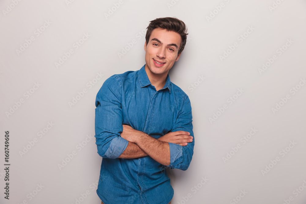smiling casual man with hands crossed standing against wall smiling casual man with hands crossed standing against wall