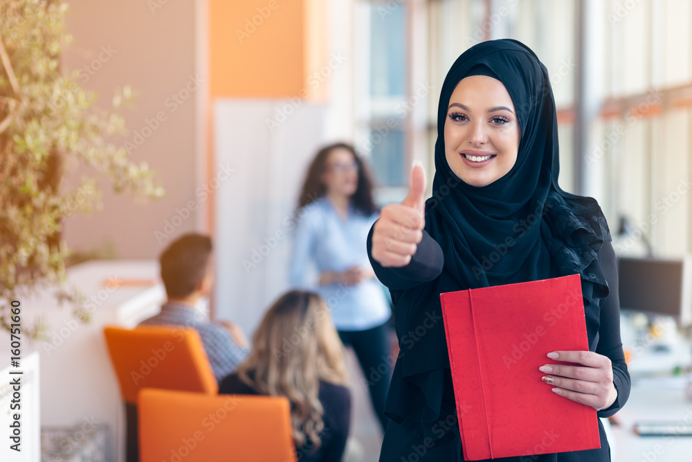 Arabian business woman with hijab holding a folder Arabian business woman with hijab holding a folder