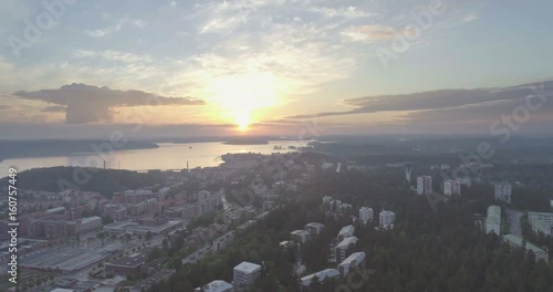Late evening aerial view of city, forest, lakes, cumulus clouds and sunset in Lahti, Finland, sideways movement