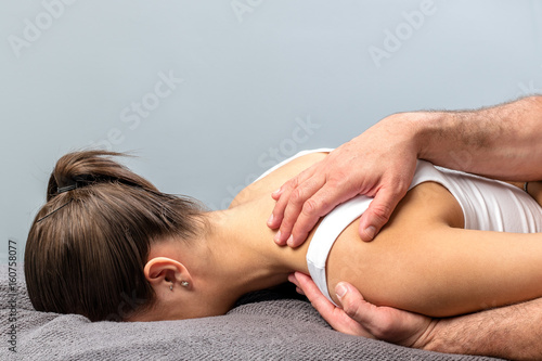 Woman having osteopathic shoulder treatment.