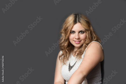 Portrait of attractive long haired young woman seductive looking at the camera. All is on the gray background. 