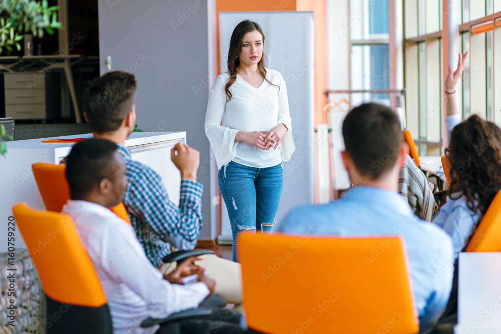 Pretty young business woman giving a presentation in conference or meeting setting. Pretty young business woman giving a presentation in conference or meeting setting.