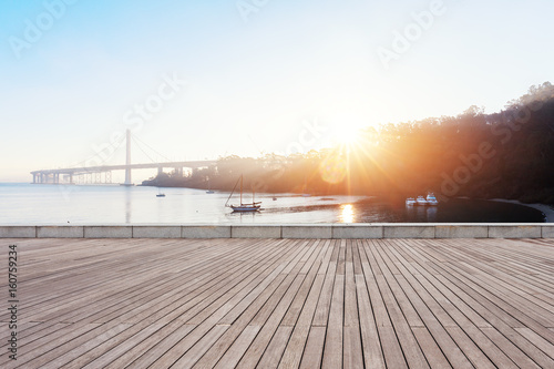 Photography empty wooden floor near modern suspension bridge with sunbeam