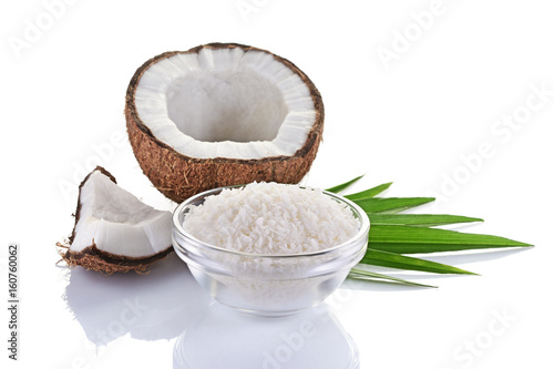 Healthy food. Fresh coconut with flakes in glass plate and green palm leaves