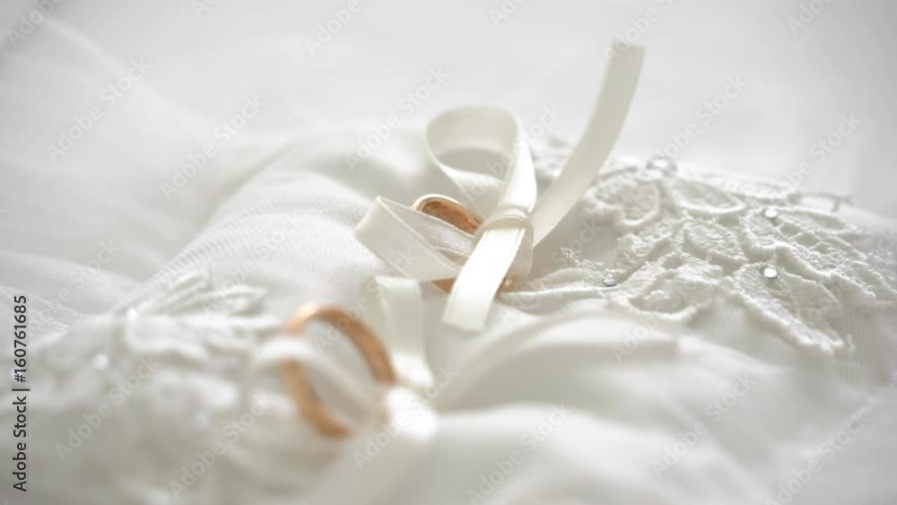 Wedding rings on a white pillow with ribbons Wedding rings on a white pillow with ribbons