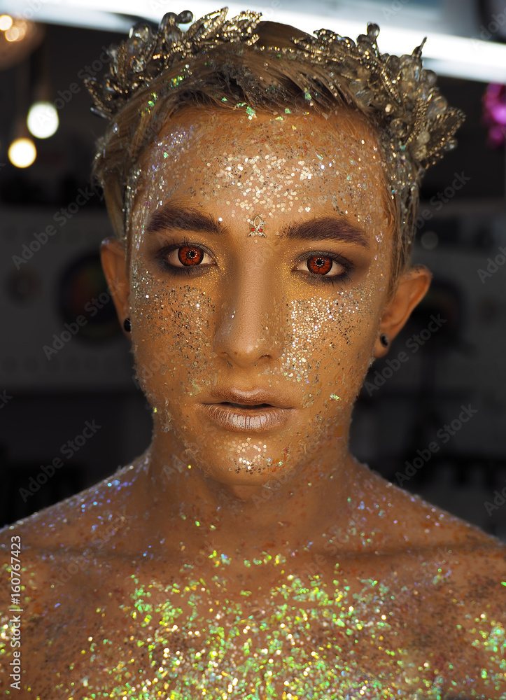 Fototapeta Young boy at the art make-up as golden caesar with red eyes