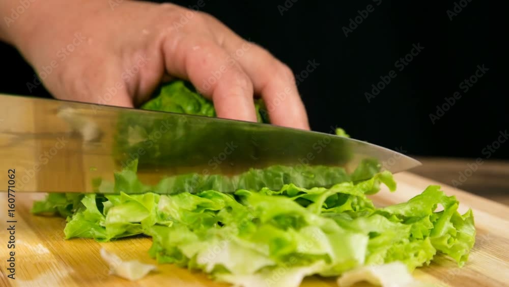 Closeup of cut green salad leaf on cutting board Closeup of cut green salad leaf on cutting board