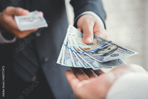 Businessman giving or paying money to a man