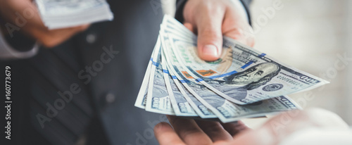 Fotografía Businessman giving or paying money, US dollar bills