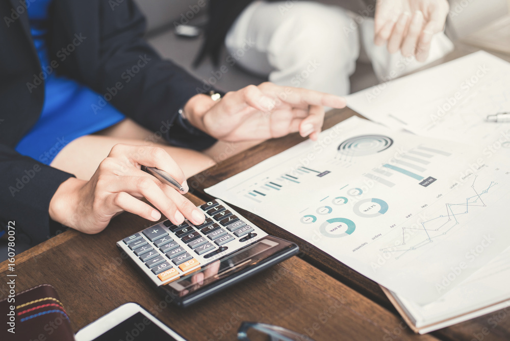 Businesswoman calculating and discussing financial documents Businesswoman calculating and discussing financial documents