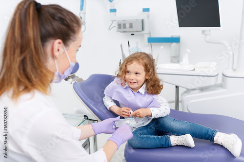 Little girl in chair visiting dentist