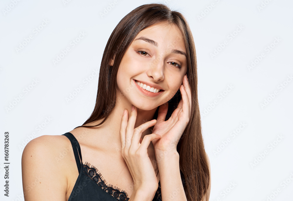 Woman with smile, woman holding hands near face, woman on light background Woman with smile, woman holding hands near face, woman on light background