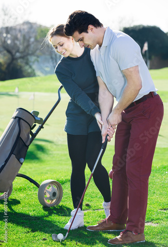 Golfer shows a man position golf clubs