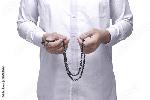 Muslim man praying with prayer beads