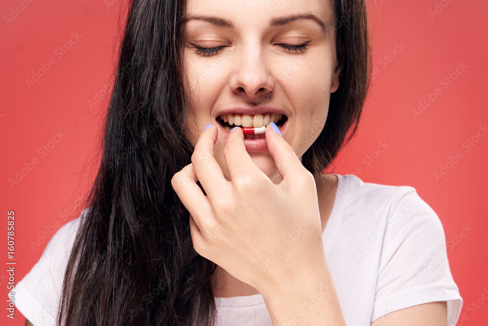 Woman with a pill, woman sick, woman on a red background Woman with a pill, woman sick, woman on a red background