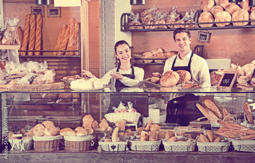 Portrait of charming couple at bakery display with pastry