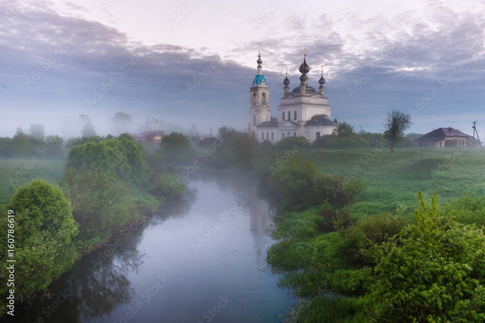 Foggy sunrise in the village Savinskoye, Yaroslavl region. Russia. The Church Of The Nativity Of The Blessed Virgin. 