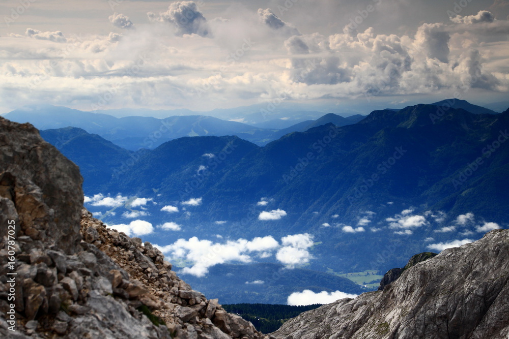 Low hanging clouds over Bohinj Valley with mountains of Bohinj Range and Slovenian Prealps, Carniola, in the background, from Kanjavec, Julian Alps, Triglav National Park, Slovenia, Europe