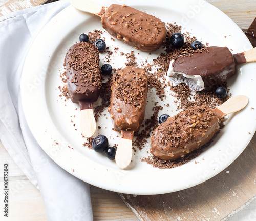 Chocolate ice cream popsicles on white plate