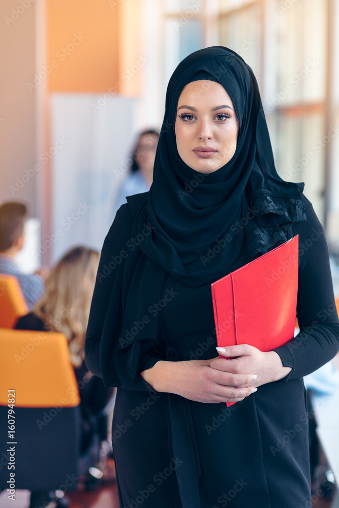 Arabian business woman with hijab holding a folder Arabian business woman with hijab holding a folder