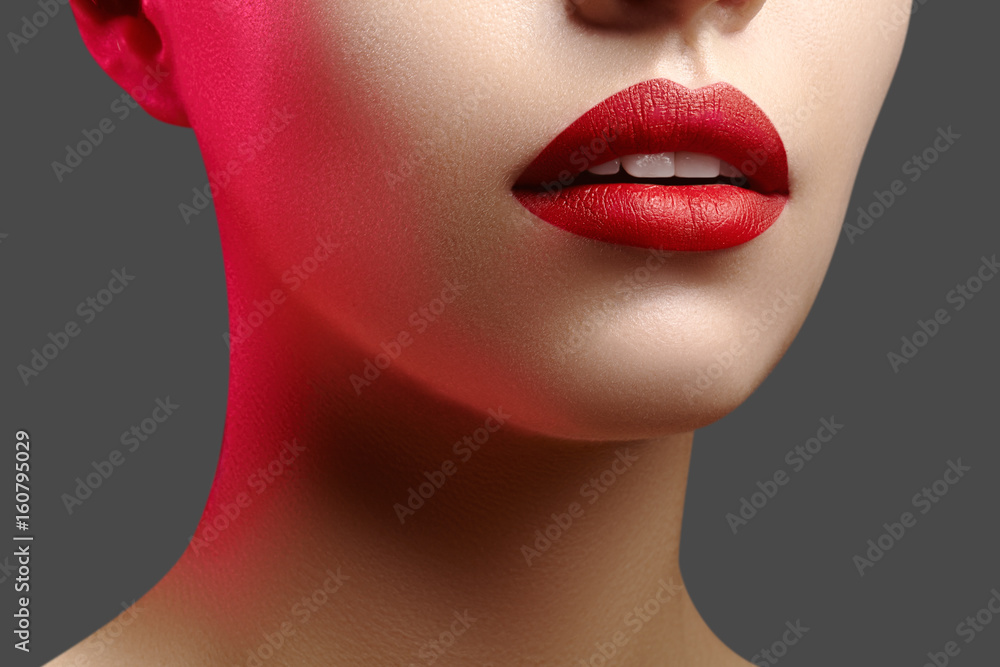 Obraz premium Cosmetics, makeup. Bright lipstick on lips. Closeup of beautiful female mouth with red lip makeup. Clean skin model