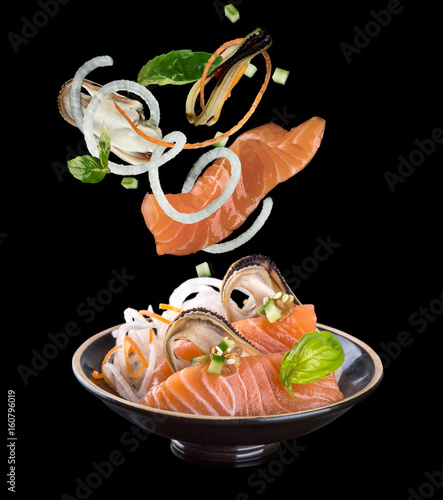 Levitation sashimi with salmon and mussel in a black plate. On a black background with reflection.